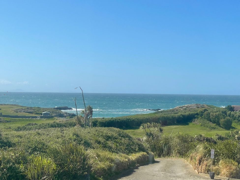 A view of the ocean and grassy land at No.7 Plas Darien in Trearddur Bay
