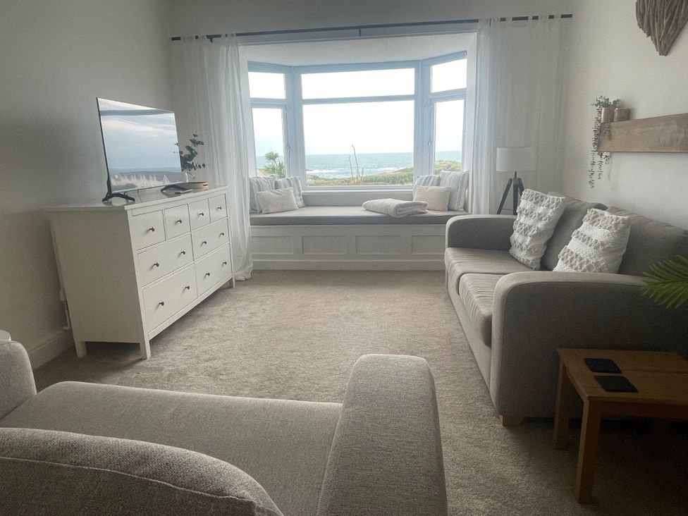 A living room with a television and a window seat at No.7 Plas Darien in Trearddur Bay