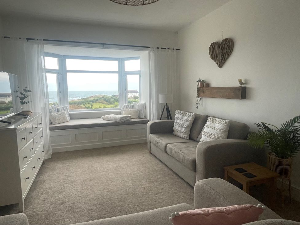 A living room with a window seat and a television at No.7 Plas Darien Trearddur Bay