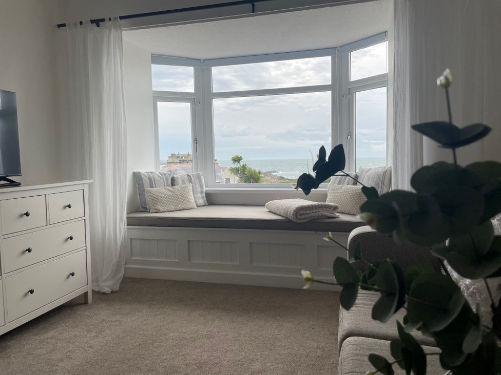 A living room with a window seat and a dresser at No.7 Plas Darien, Trearddur Bay