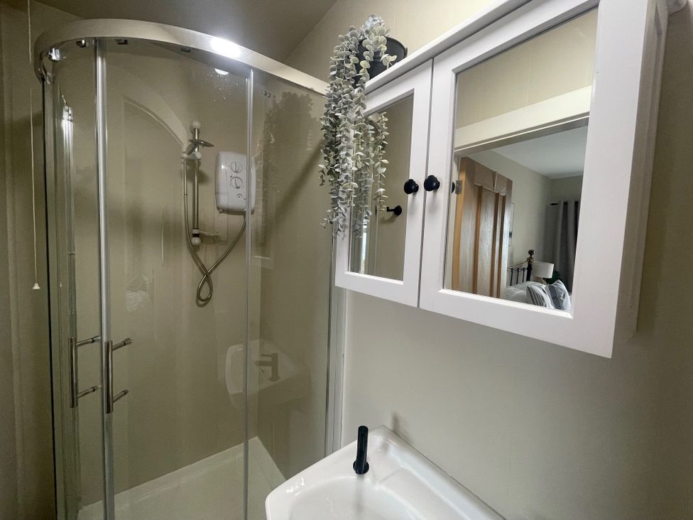 A bathroom with a shower and sink at No.7 Plas Darien Trearddur Bay