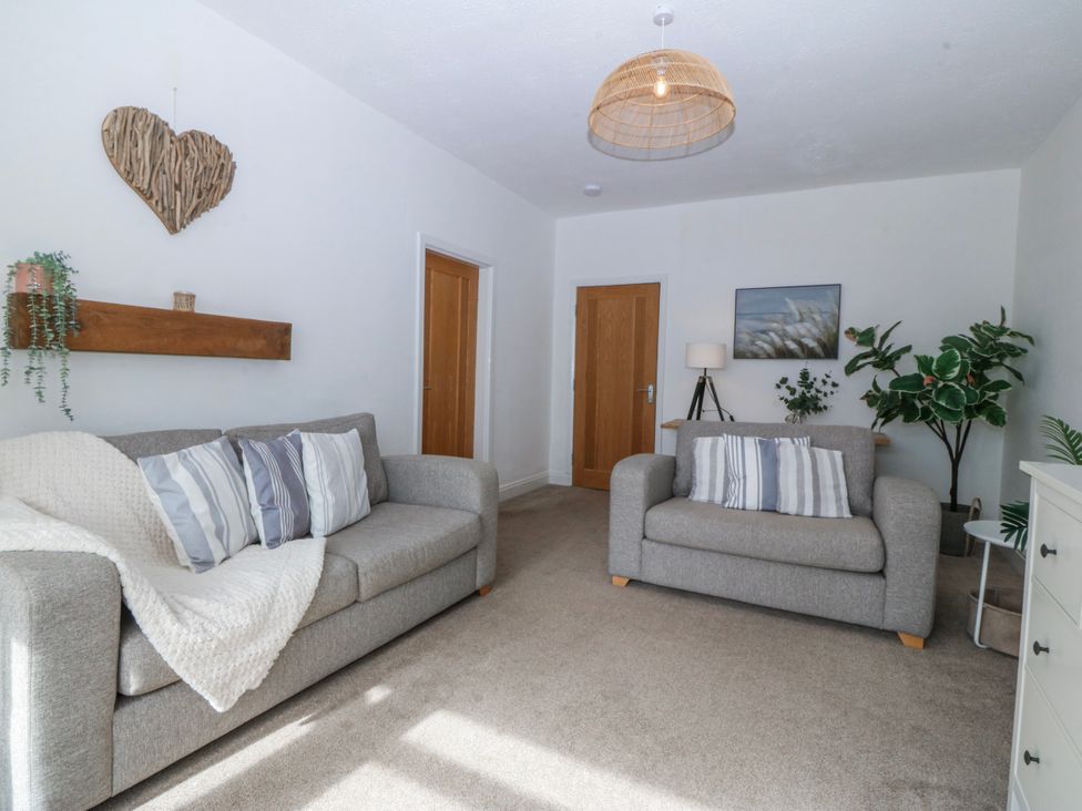 A living room with two sofas and a shelf at No.7 Plas Darien in Trearddur Bay