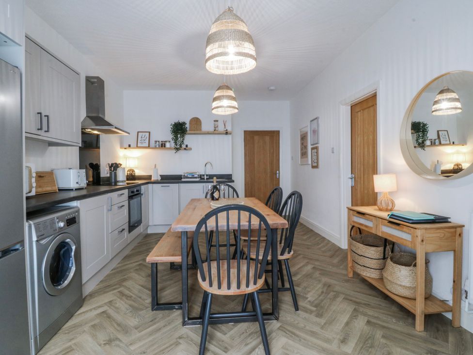 A kitchen with a dining table and chairs at No.7 Plas Darien, Trearddur Bay
