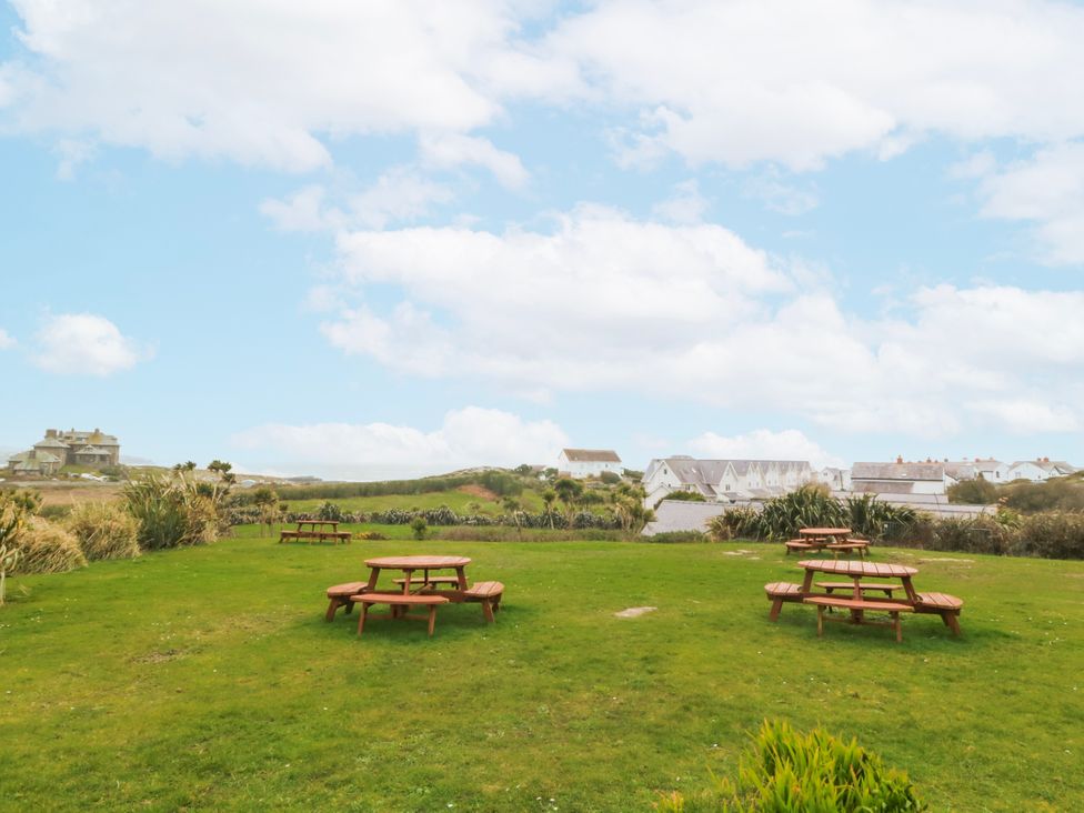 An outdoor area with picnic tables and grass at No.7 Plas Darien Trearddur Bay