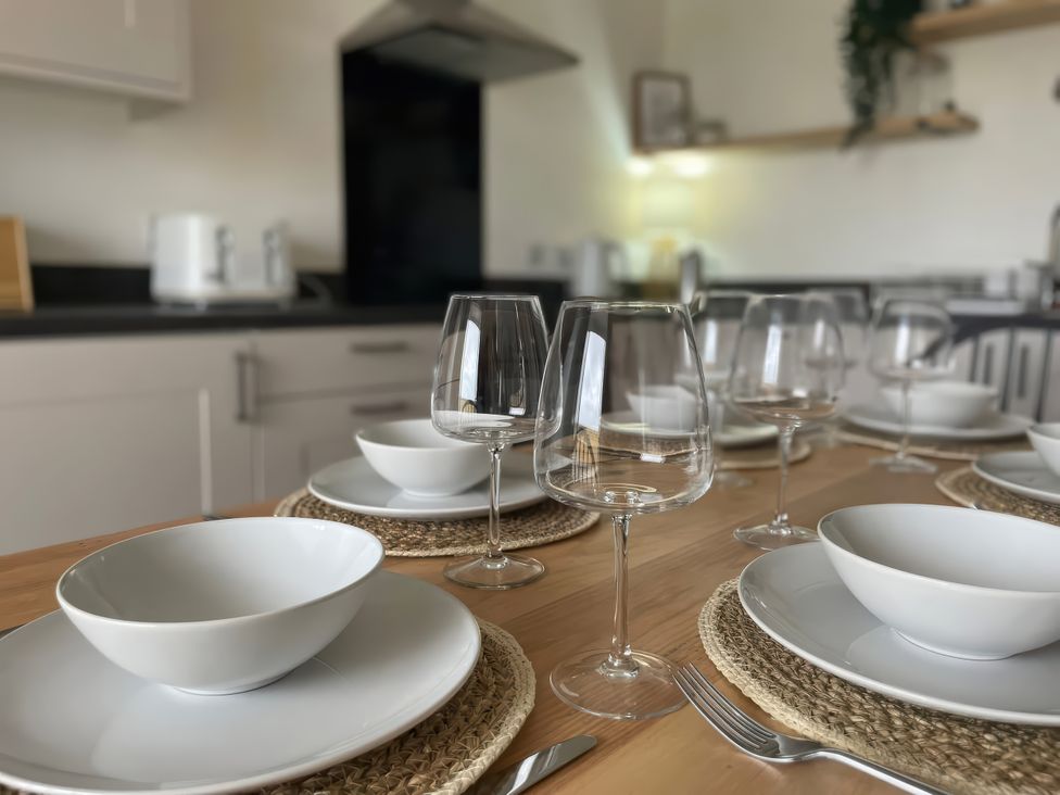 A dining table set with plates, bowls, and glasses at No.7 Plas Darien Trearddur Bay