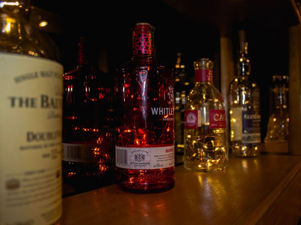 A collection of various bottles lined up on a shelf at Crannoch Self Catering, Buckie