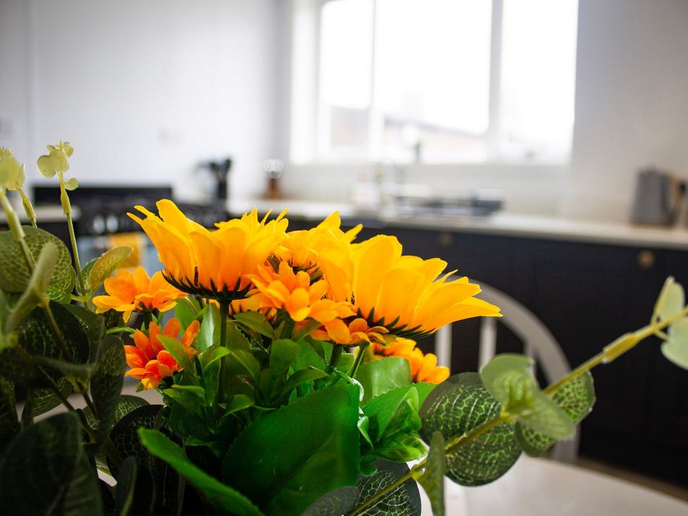 A kitchen with flowers on a table at Crannoch Self Catering Buckie