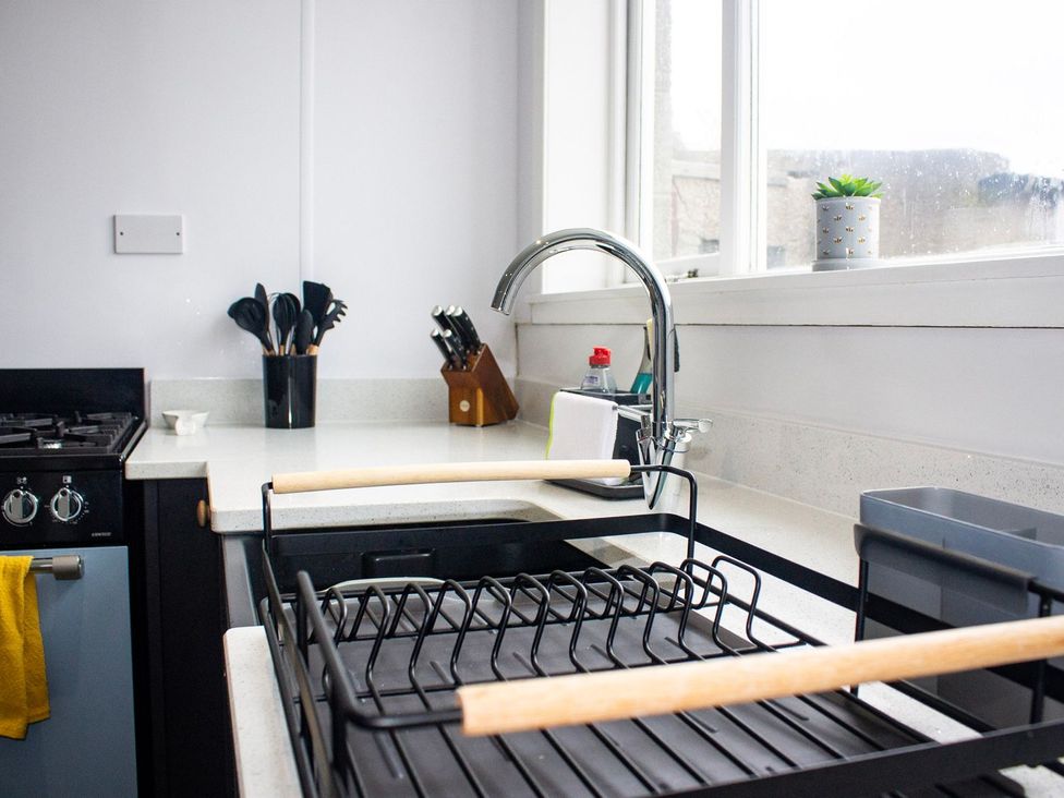 A kitchen with a sink and dish rack at Crannoch Self Catering Buckie