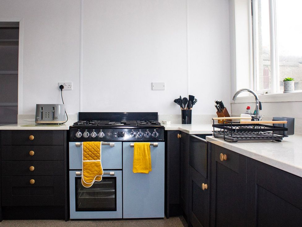A kitchen with an oven, sink, and utensils at Crannoch Self Catering in Buckie