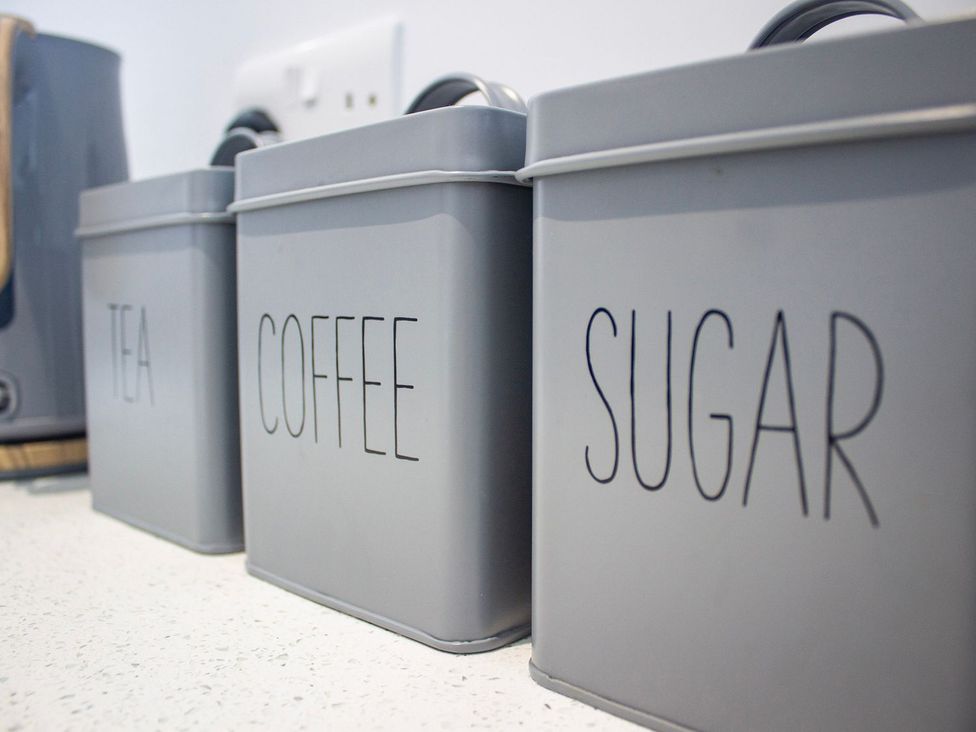 A kitchen with tea, coffee, and sugar canisters at Crannoch Self Catering in Buckie