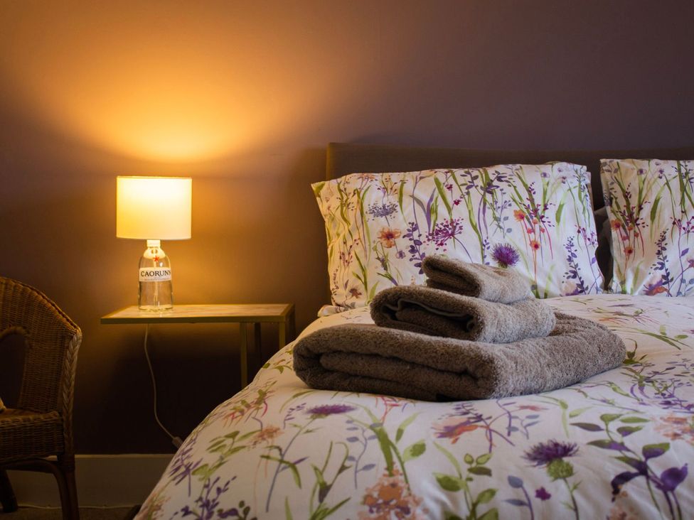 A bedroom with a bed and towels on a side table at Crannoch Self Catering in Buckie