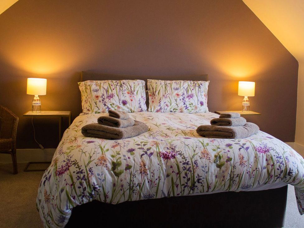 A bedroom with a bed and lamps at Crannoch Self Catering Buckie