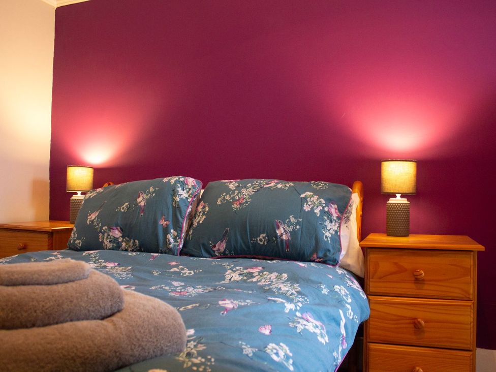 A bedroom with a bed and bedside lamps at Crannoch Self Catering Buckie