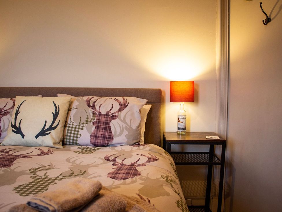 A bedroom with a bed and bedside table at Crannoch Self Catering in Buckie
