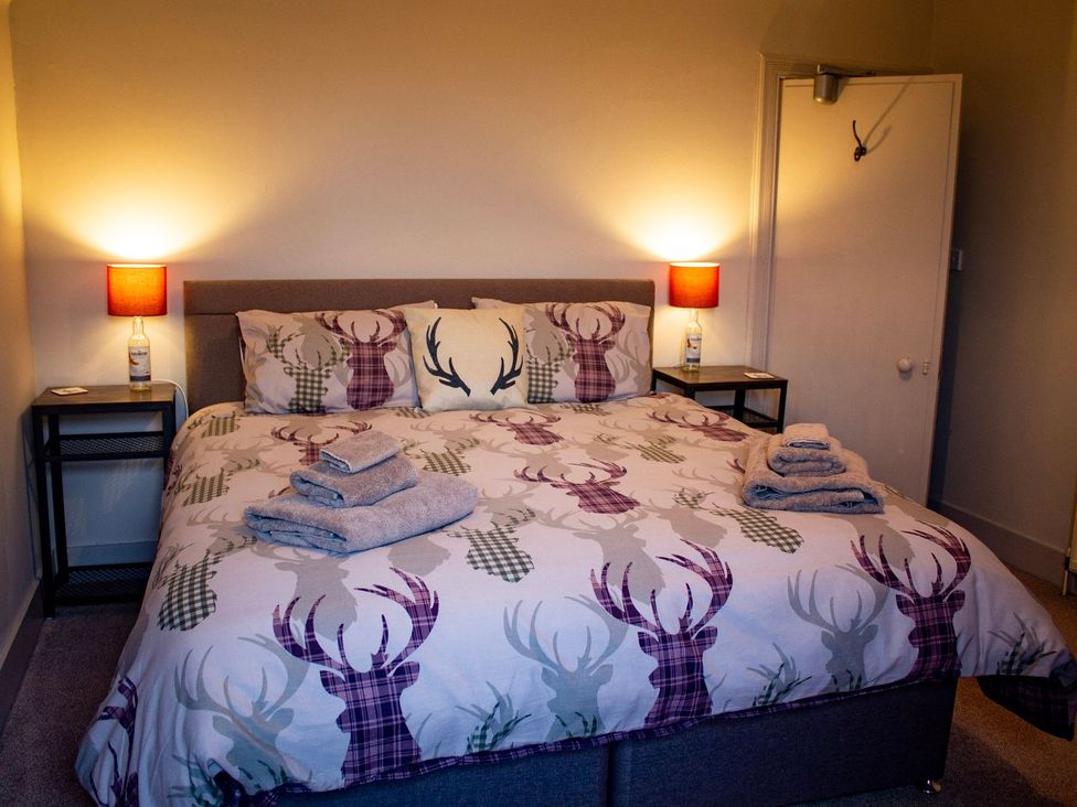 A bedroom with a bed and bedside tables at Crannoch Self Catering in Buckie