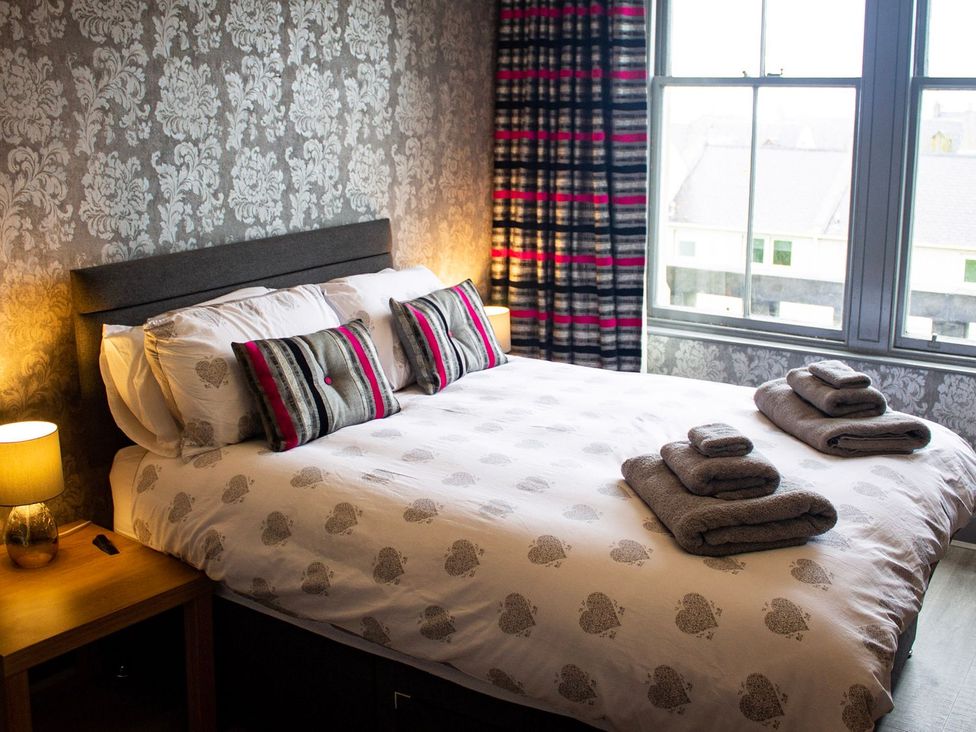 A bedroom with a bed and towels at Crannoch Self Catering in Buckie