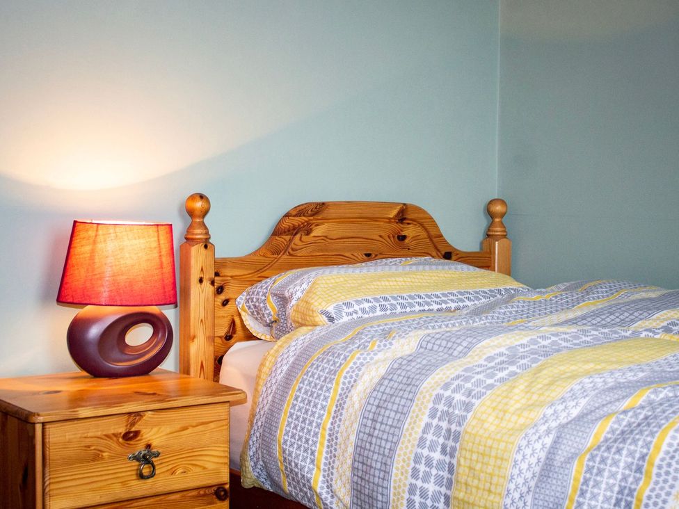 A bedroom with a bed and a bedside lamp at Crannoch Self Catering in Buckie