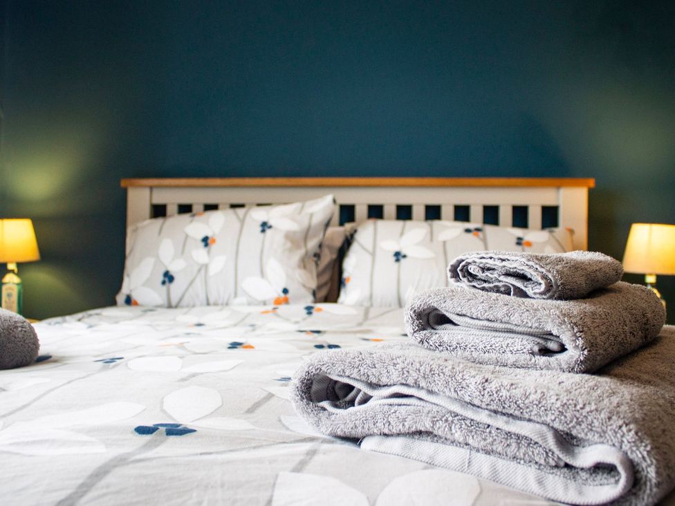 A bedroom with a bed and towels at Crannoch Self Catering in Buckie