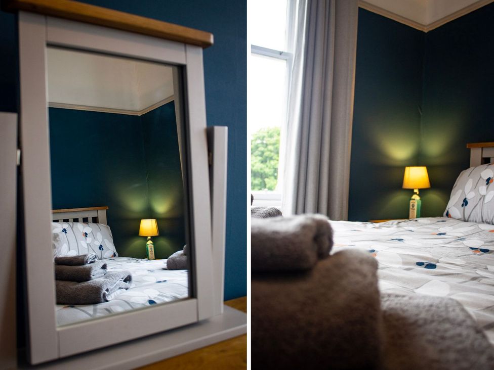 A bedroom with a mirror and lamp at Crannoch Self Catering in Buckie