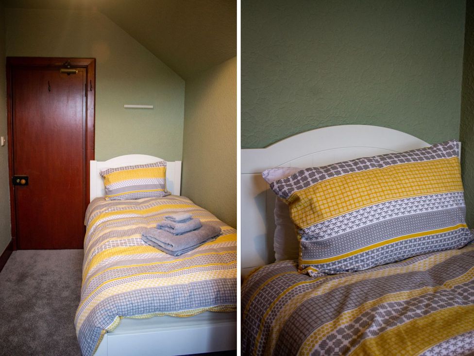 A bedroom with a single bed and a door at Crannoch Self Catering in Buckie