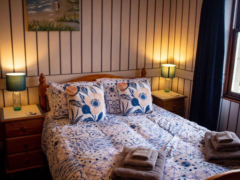 A bedroom with a bed and bedside tables at Crannoch Self Catering Buckie