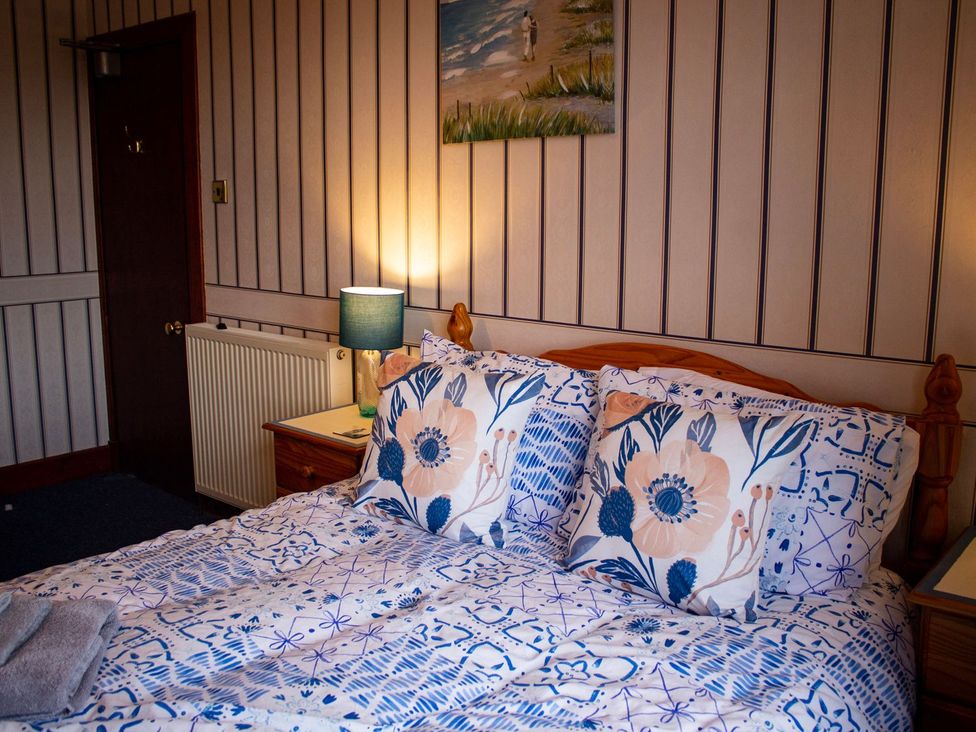 A bedroom with a bed and lamp at Crannoch Self Catering in Buckie