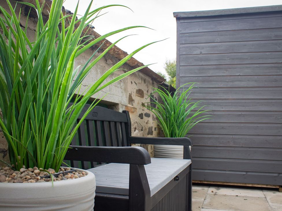 A seating area with a bench and potted plants at Crannoch Self Catering in Buckie