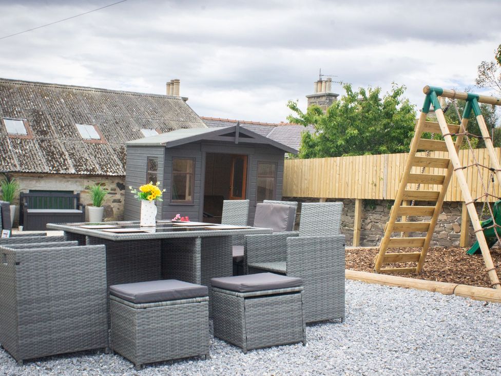 An outdoor seating area with a table and chairs at Crannoch Self Catering in Buckie