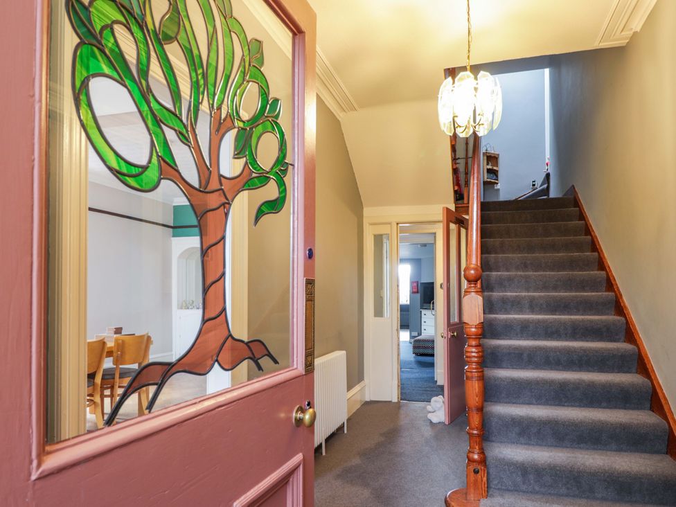 A hallway with stairs and a stained glass door at Crannoch Self Catering in Cullen