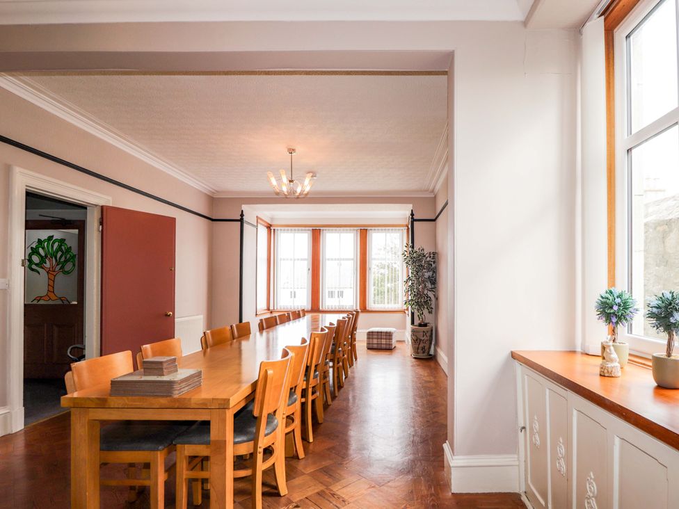 A dining room with a long table and chairs at Crannoch Self Catering, Cullen
