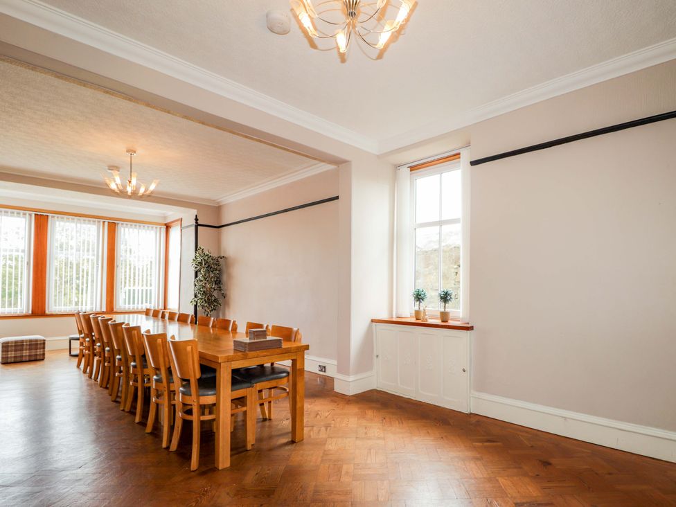 A dining room with a long table and chairs at Crannoch Self Catering in Cullen