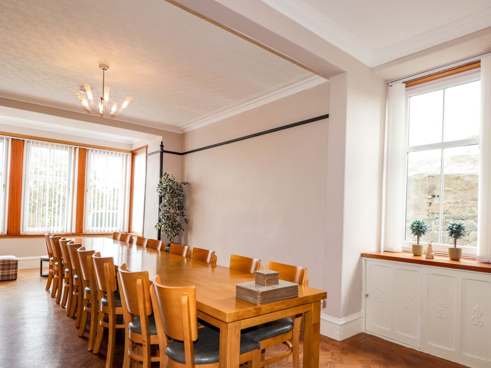 A dining room with a long table and chairs at Crannoch Self Catering in Cullen