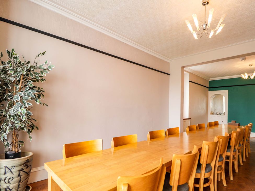A dining room with a long table and chairs at Crannoch Self Catering in Cullen