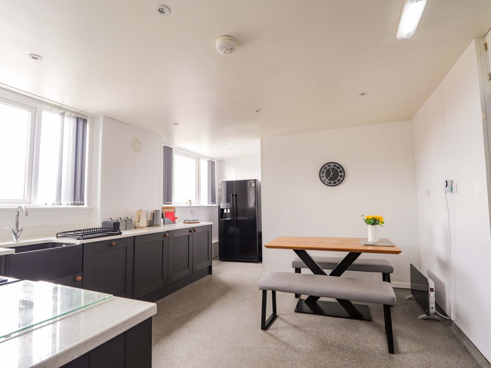 A kitchen with a table and benches at Crannoch Self Catering in Cullen