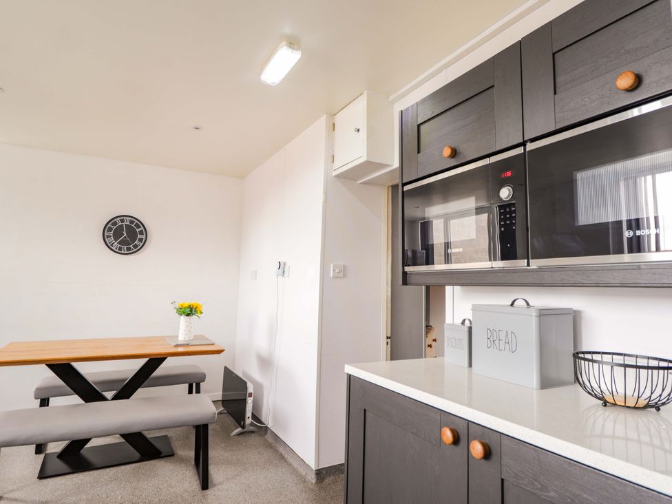 A kitchen with a table and benches at Crannoch Self Catering in Cullen