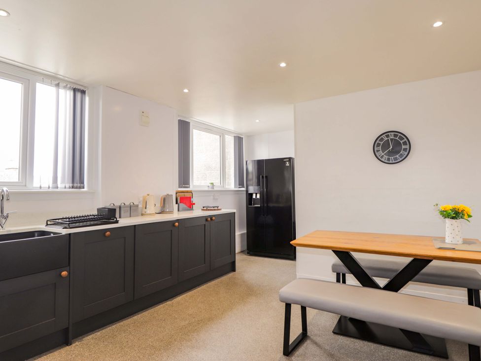 A kitchen with a dining table and refrigerator at Crannoch Self Catering in Cullen