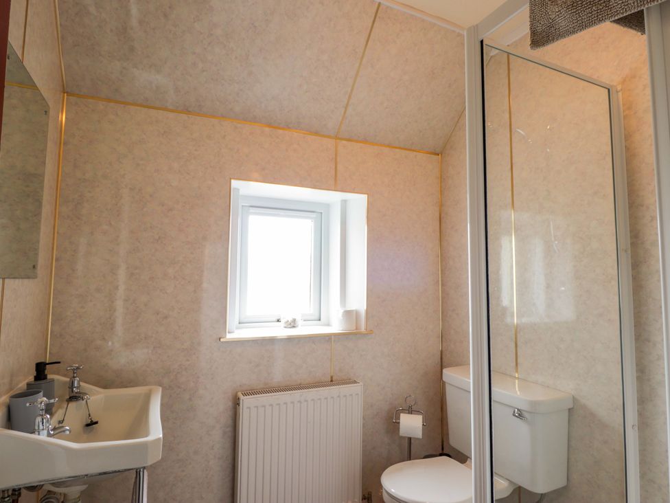 A bathroom with a sink, toilet, and shower at Crannoch Self Catering in Cullen