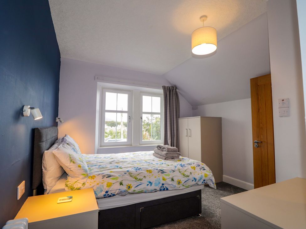 A bedroom with a bed and wardrobe at Crannoch Self Catering Cullen