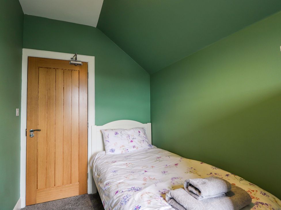 A bedroom with a bed and towels at Crannoch Self Catering in Cullen