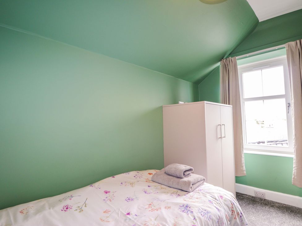 A bedroom with a bed and wardrobe at Crannoch Self Catering in Cullen