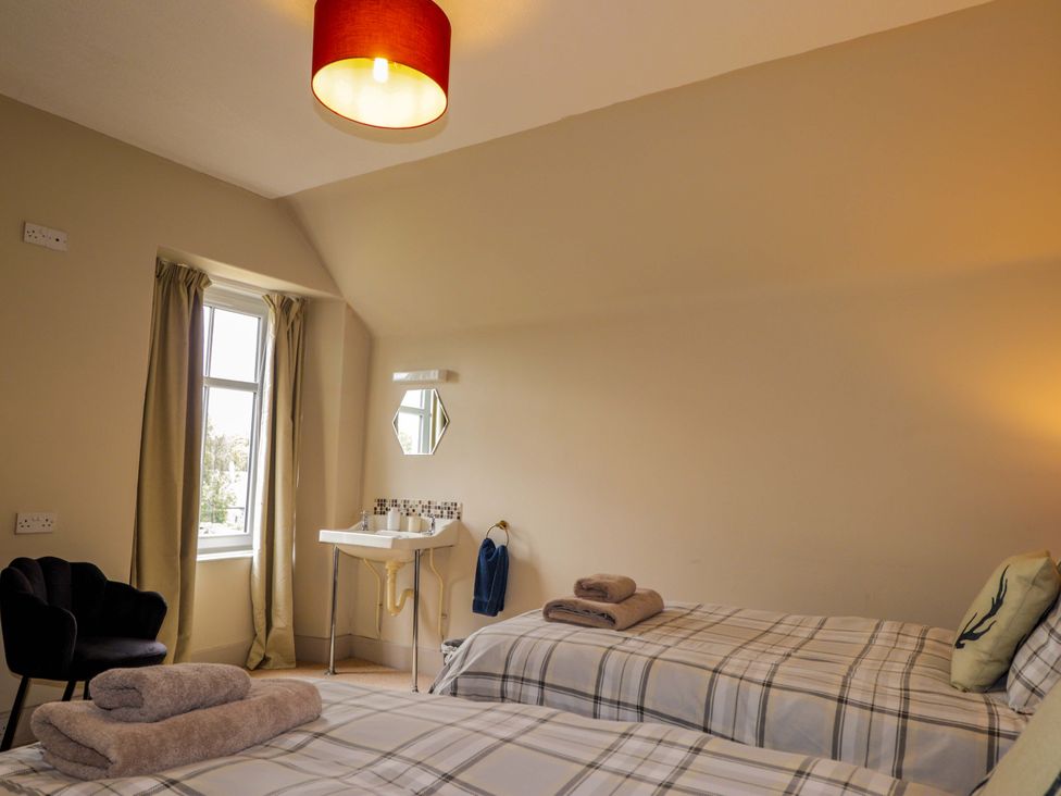 A bedroom with two beds and a sink at Crannoch Self Catering in Cullen