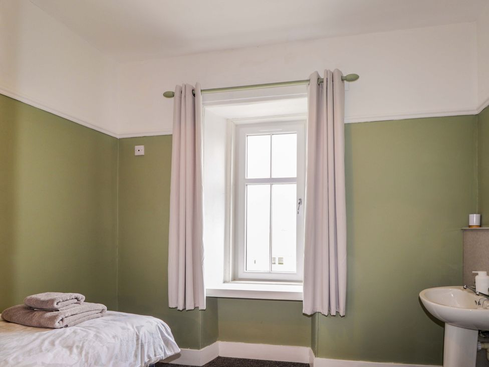 A bedroom with a bed and towels at Crannoch Self Catering in Cullen