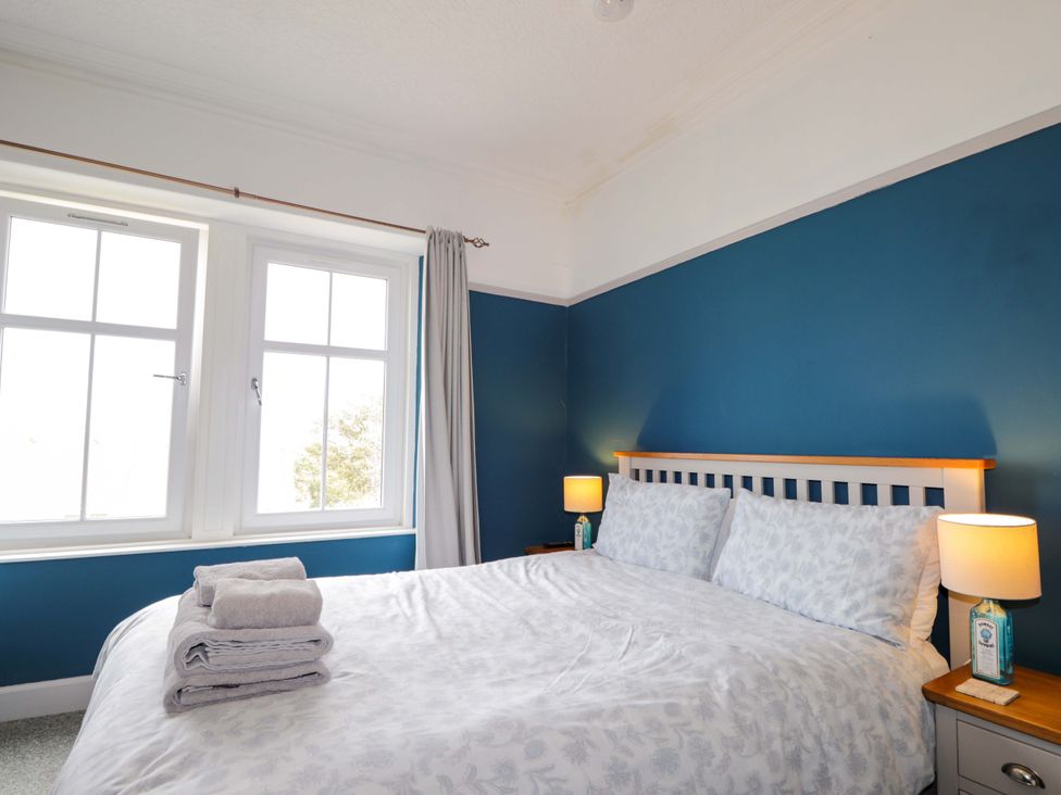 A bedroom with a bed and two lamps at Crannoch Self Catering in Cullen