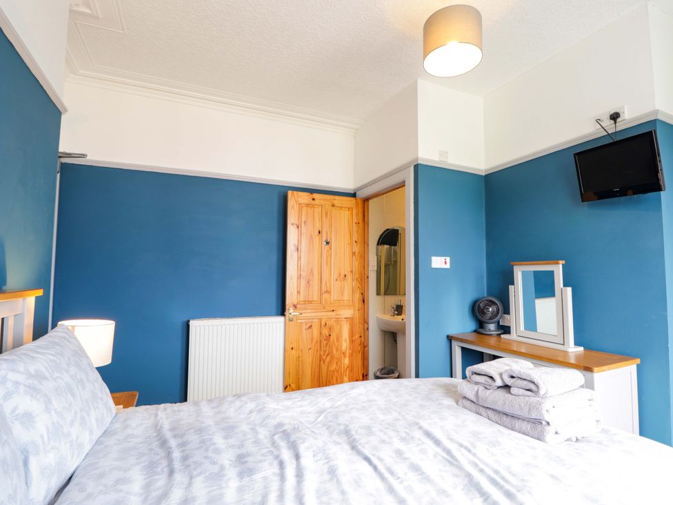 A bedroom with a bed and a mirror at Crannoch Self Catering in Cullen