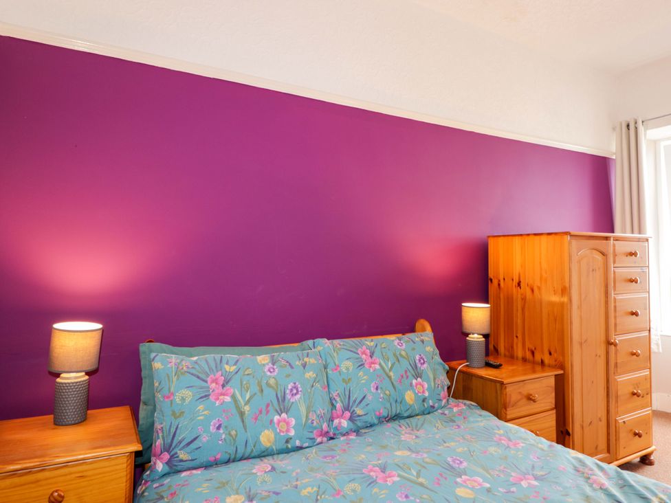 A bedroom with a bed and wooden furniture at Crannoch Self Catering in Cullen