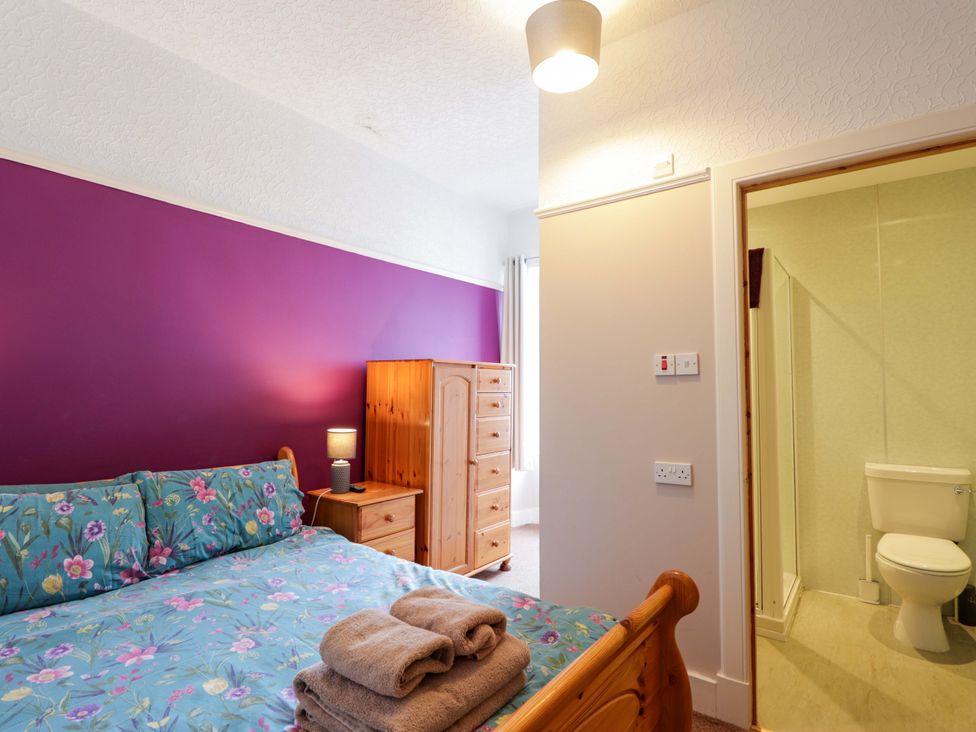 A bedroom with bed, chest of drawers and en-suite bathroom at Crannoch Self Catering in Cullen