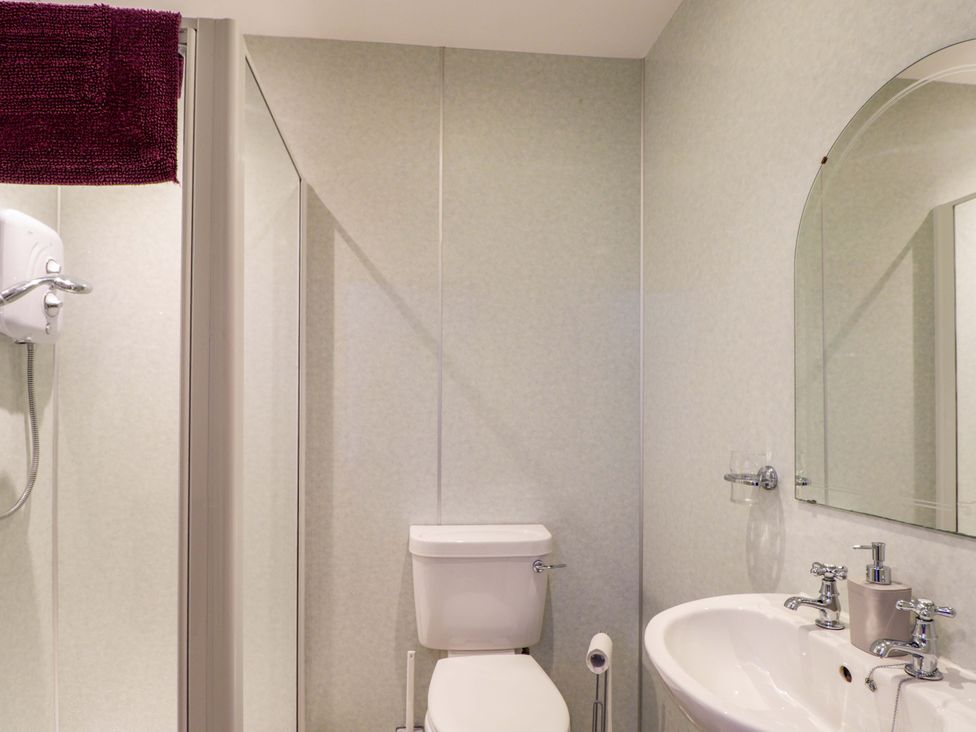 A bathroom with a toilet, sink, and shower at Crannoch Self Catering in Cullen
