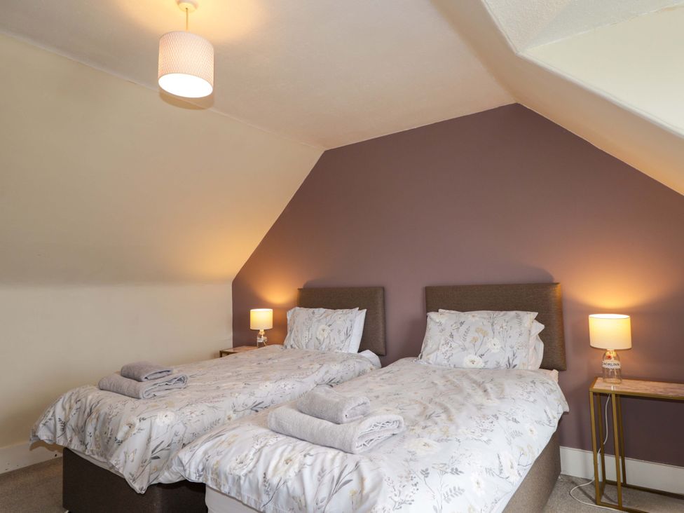A bedroom with two beds and bedside tables at Crannoch Self Catering in Cullen