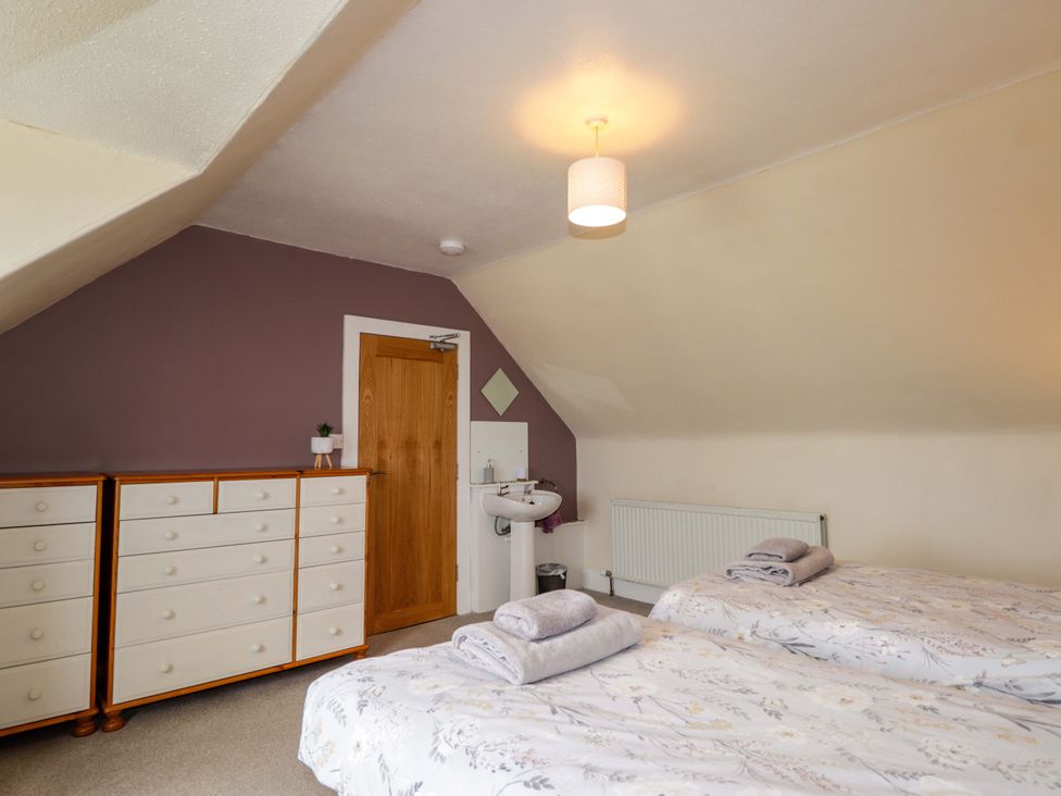 A bedroom with two beds and a dresser at Crannoch Self Catering in Cullen