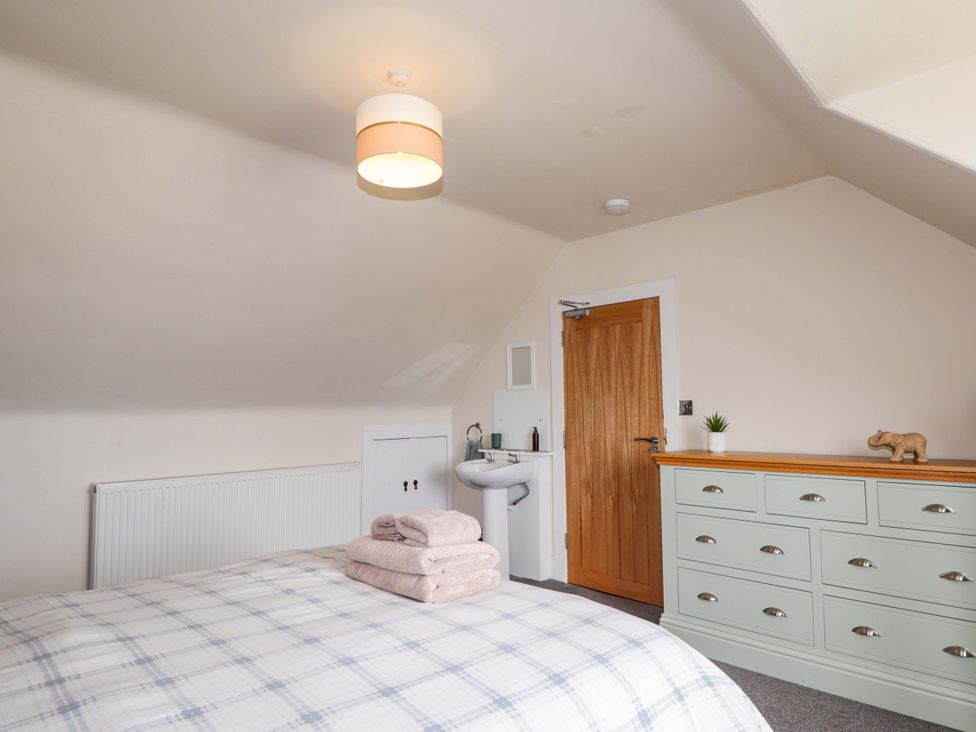 A bedroom with a bed and wash basin at Crannoch Self Catering in Cullen